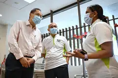 (Dari kiri) Menteri Tenaga Manusia, Dr Tan See Leng, berinteraksi dengan dua penolong terapi, Encik Sabar Halomoan Butar dan Cik Anne Mary Shanthini, semasa lawatannya ke Hospital Masyarakat Yishun pada 28 November. 
