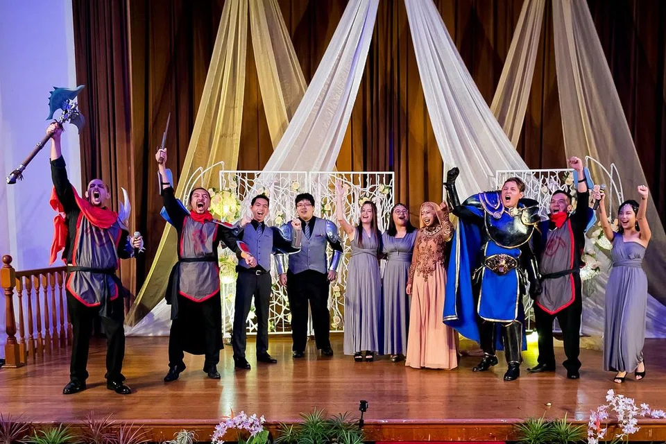 SKETSA MENYERONOKKAN: Ada sketsa ringkas siap dengan aksi lawan bagi tontonan tetamu. Encik Muhammad Zaki (tiga dari kanan) bertindak selaku satria yang datang untuk menyelamatkan isterinya, Cik Siti Zahara (berdiri di sebelahnya). - Foto RAYMOND PHANG PHOTOGRAPHY