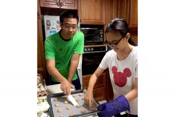 LEBIH MESRA: Selepas berhenti merokok, hubungan Encik Muhammad Adib Ismail dengan keluarganya, termasuk adiknya, Cik Nur Adilah Ismail, lebih rapat. Mereka sedang mengatur kuih yang disiapkan sempena Hari Raya Aidilfitri tidak lama lagi. - Foto ihsan MUHAMMAD ADIB ISMAIL