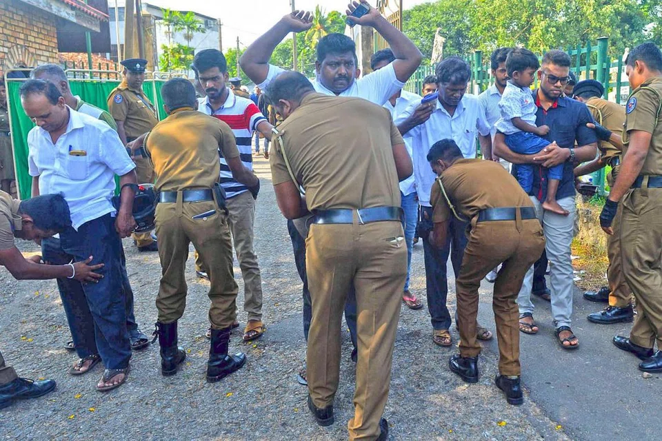 PEMERIKSAAN RAPI: Anggota polis Sri Lanka memeriksa orang ramai yang menghadiri upacara pengebumian korban serangan bom di Colombo, tiga hari selepas serangan bom itu yang membunuh 359 orang dan lebih 500 yang lain cedera. - Foto AFP