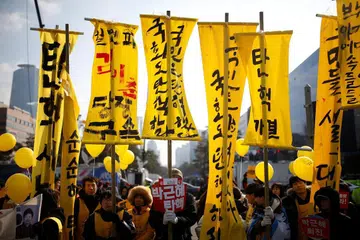BANTAHAN RAKYAT: Penunjuk perasaan berkumpul di luar bangunan Parlimen di Seoul sambil menuntut agar Cik Park dipecat. - Foto REUTERS