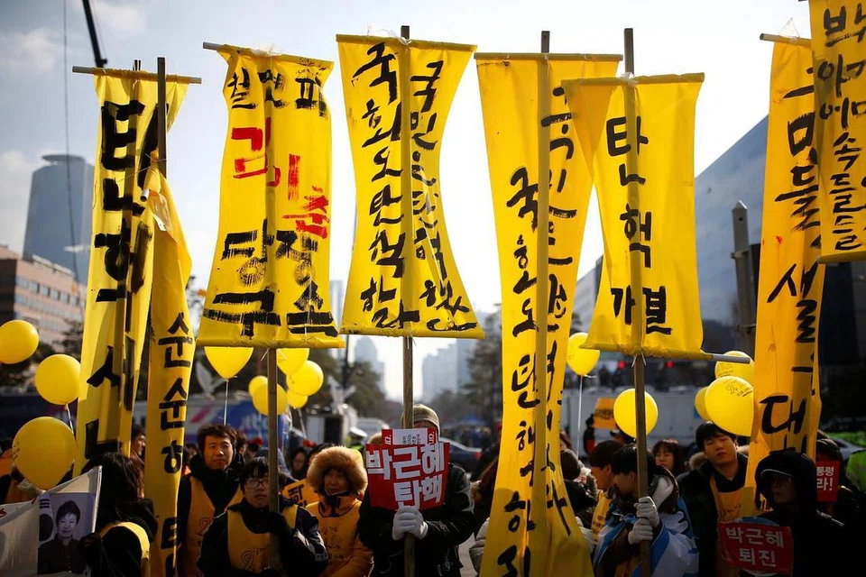 BANTAHAN RAKYAT: Penunjuk perasaan berkumpul di luar bangunan Parlimen di Seoul sambil menuntut agar Cik Park dipecat. - Foto REUTERS
