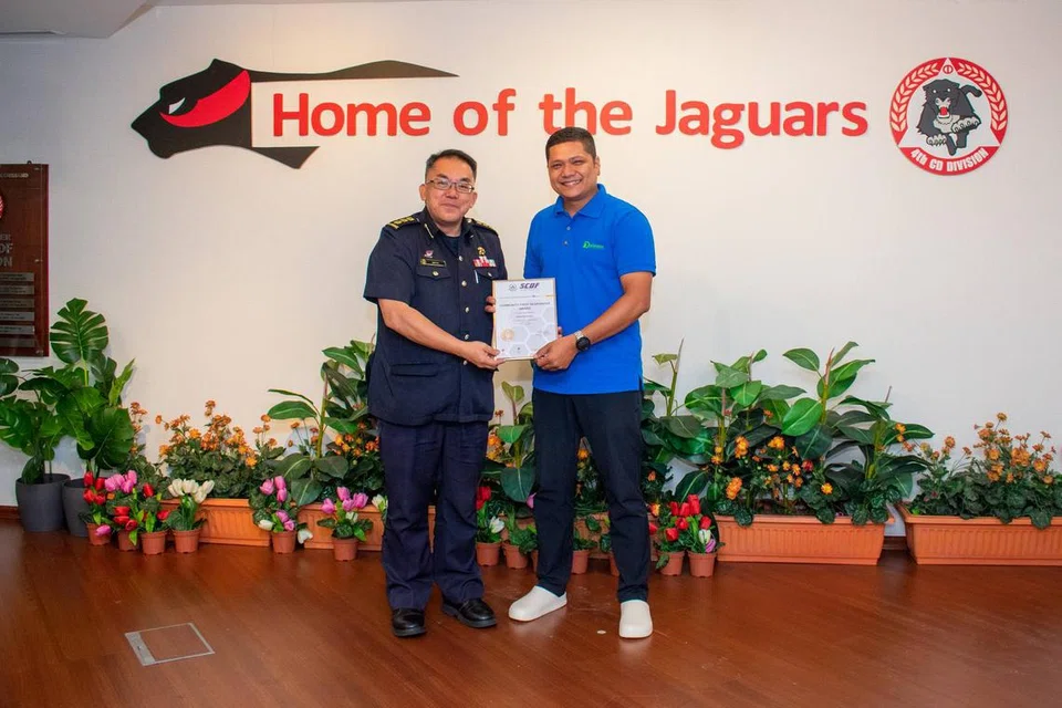 Encik Zakee Zulkifli (kanan) menerima Anugerah Penggerak Balas Pertama Masyarakat Pasukan Pertahanan Awam Singapura (SCDF) daripada Timbalan Pengarah Jabatan Kerjasama Sukarelawan dan  Masyarakat SCDF, Kolonel (COL) Bob Tan, setelah beliau memadam kebakaran lori sampah di Ekspreswe Ayer Rajah (AYE) menghala Ekspreswe Pantai Marina (MCE) sebelum susur keluar Tuas Road pada 22 April.