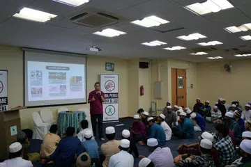 TEKANKAN MESEJ: Menteri Negara (Ehwal Dalam Negeri merangkap Pembangunan Negara), Profesor Madya Muhammad Faishal Ibrahim (berdiri), memberi ucapan kepada hadirin yang menyertai program anjuran Dadah Itu Haram dan Persatuan Perkhidmatan Sosial India Muslim di Masjid An-Nahdhah.