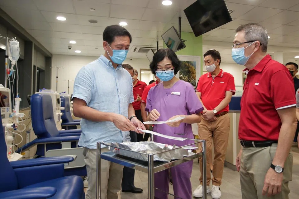 LAWAT PUSAT DIALISIS: Encik Ong Ye Kung (kiri) melihat jarum dialisis yang ditunjukkan Pengurus Jururawat NKF, Cik Pan Mei Yu, semasa lawatannya ke Pusat Dialisis NKF di Hospital Masyarakat Yishun semalam. Bersama mereka ialah CEO Keppel Corporation, Encik Loh Chin Hua (dua dari kanan) dan CEO NKF, Encik Tim Oei (kanan). - Foto BH oleh GIN TAY
