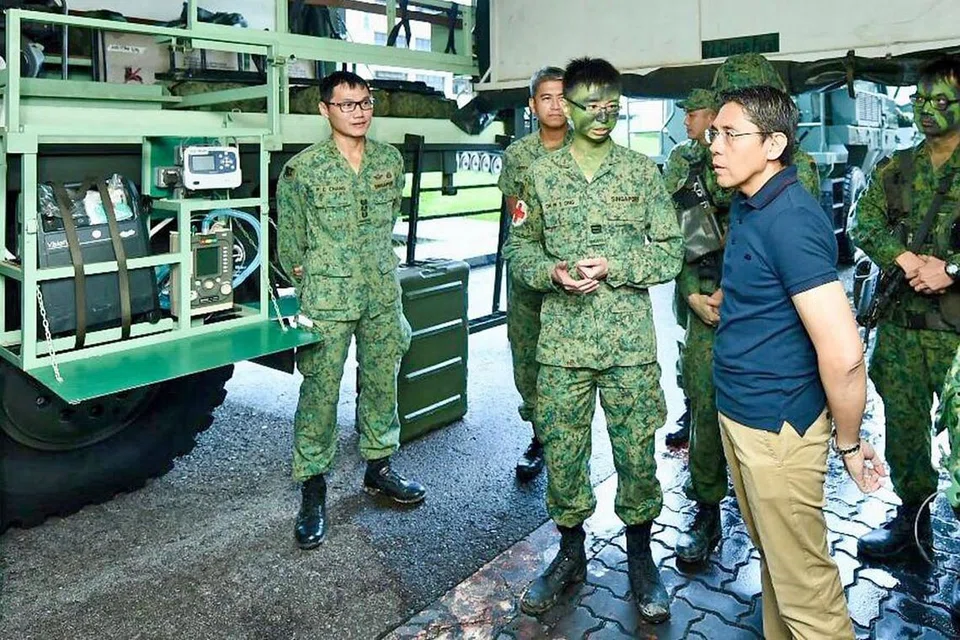 TUNGGAK PERTAHANAN SINGPURA: Dr Maliki, yang dirakam berinteraksi dengan anggota kerahan menjalani latihan di Kem Sungei Gedong semalam, melihat NS sebagai tunggak SAF dan pertahanan Singapura. - Foto MINDEF