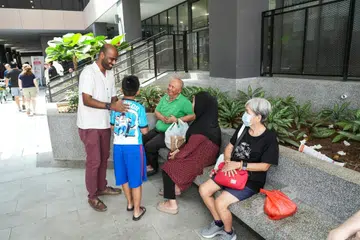 Anggota Parlimen GRC Jurong, Dr Hamid Razak, beramah mesra dengan sebuah keluarga yang hadir semasa pelancaran One Care @Jurong Spring pada 25 April lalu. 