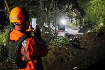 MALANG TAK BERBAU: Anggota Agensi Mencari dan Menyelamat Kebangsaan membawa keluar mangsa kemalangan bas terjunam di Sumedang, Jawa Barat, malam tadi. - Foto AFP