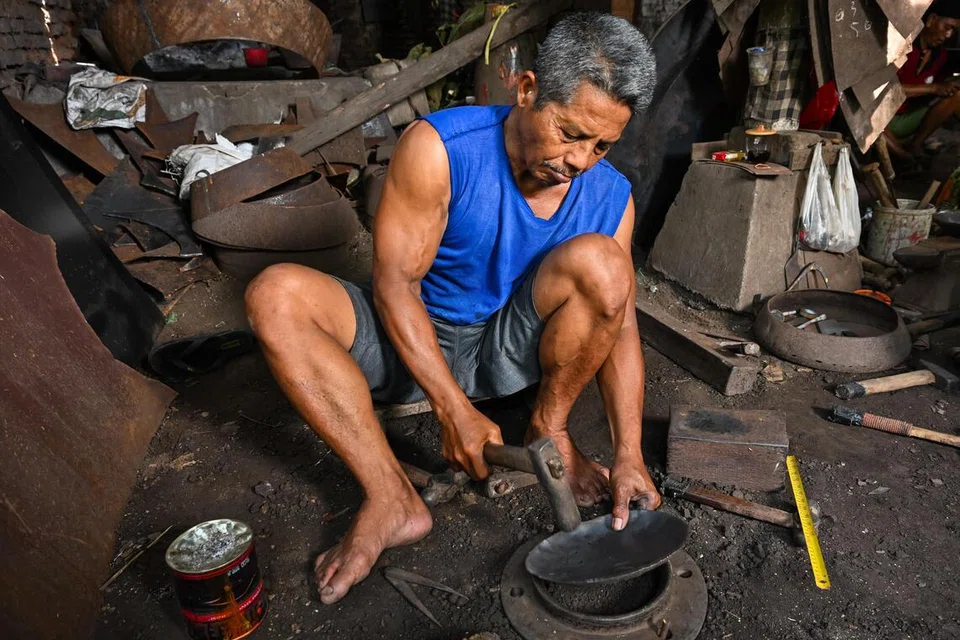 Seorang petukang mengetuk logam secara berterusan bagi membentuknya secara berperingkat. 
