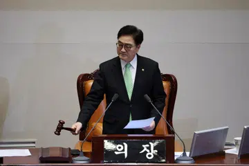 Speaker Dewan Negara, Encik Woo Won-shik, mengetuk tukul selepas mengumumkan keputusan pada hari undian pemecatan Pemangku Presiden yang juga Perdana Menteri Korea Selatan, Encik Han Duck-soo, semasa sesi pleno di Dewan Negara, Seoul, pada 27 Disember. 