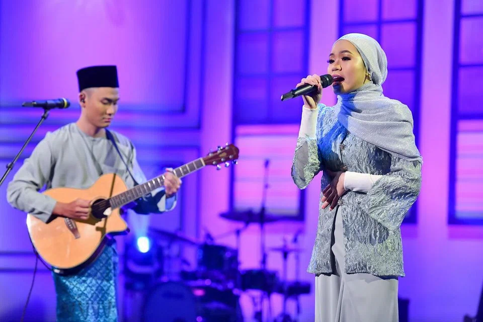 PENGALAMAN SULUNG: Duo adik-beradik, Anak-Anak Haron, yang terdiri daripada Ahmadul Amin (kiri) dan Nuur Afiqah Haron, bereksperimen dengan versi akustik lagu Najwa Latif, 'Hari Raya Kita' dalam rancangan hiburan, 'Rayakustika 2021' pada 8.30 malam ini. - Foto MEDIACORP SURIA
