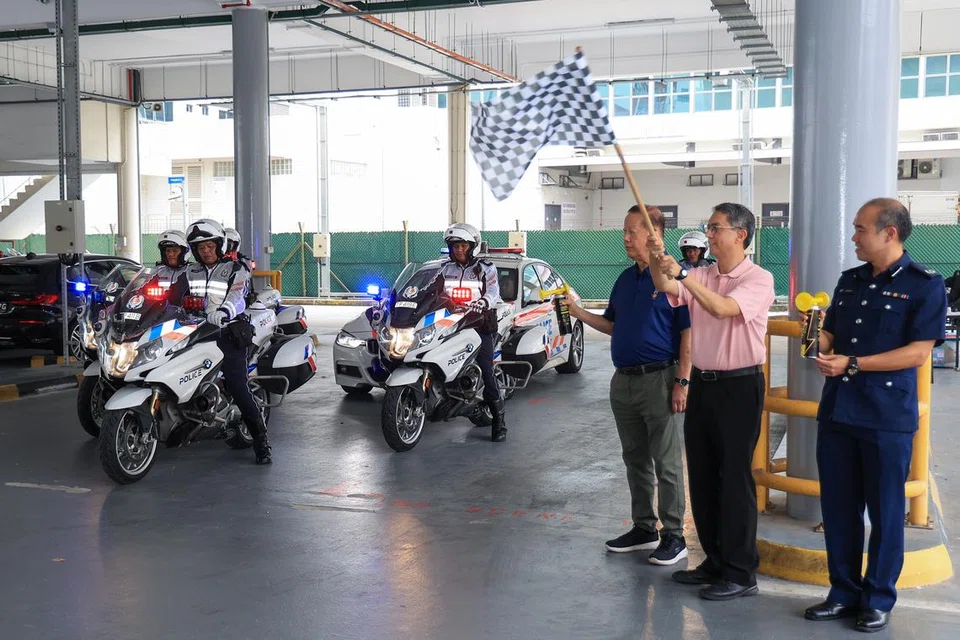 Profesor Madya Dr Muhammad Faishal Ibrahim mengibarkan bendera bagi melancarkan kempen, ‘Ganjaran kepada Pemandu Berhemah’. Bersamanya ialah pengerusi Majlis Keselamatan Jalan Raya Singapura (SRSC), Encik Bernard Tay (kiri) dan Timbalan Komander Polis Trafik, Timbalan Penolong Pesuruhjaya (DAC) Lionel Bok.