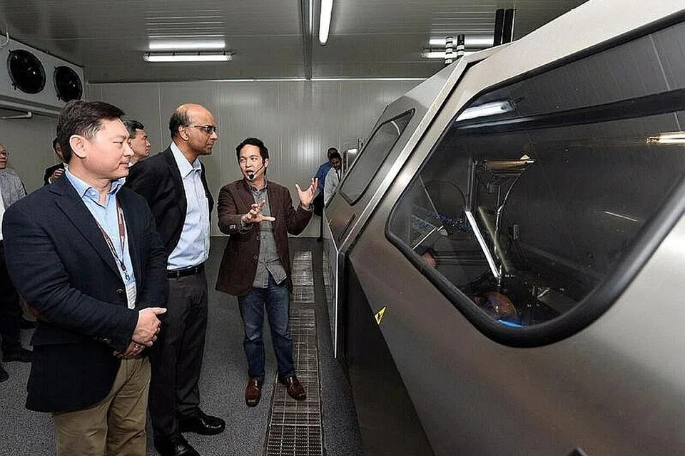 MELABUR PERALATAN CANGGIH: Encik Tharman (tengah) dan Encik Kwan (kiri) melihat sebuah peralatan memproses makanan tekanan tinggi yang terdapat di bangunan baru, Commonwealth Capital. - Foto COMMONWEALTH CAPITAL
