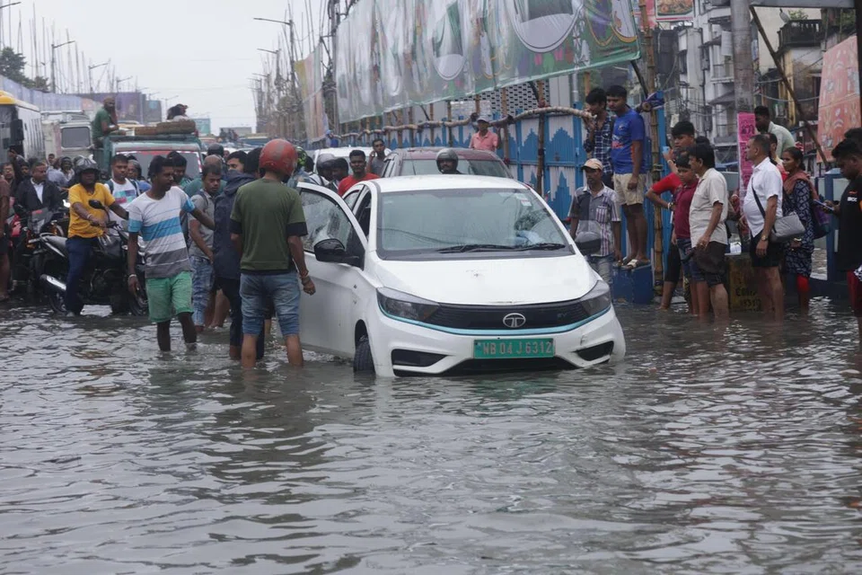 Orang ramai meredah jalan yang digenangi air selepas hujan lebat di kota timur India, Kolkata, 23 September 2025. Jabatan Meteorologi India (IMD) telah mengeluarkan amaran kuning bagi ribut petir dengan kilat serta hujan lebat, yang dijangka mengganggu kehidupan harian di Bengal Barat untuk tiga hari akan datang. 
