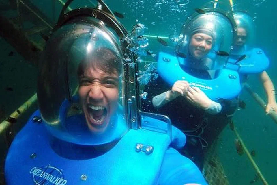 SERONOK: Penulis dan isterinya, Cik Nurul Huda Abdul Khalid, semasa melakukan 'seabed walking' atau berjalan di dasar laut di Borneo Reef World Pontoon di Taman Marin Tengku Abdul Rahman. - Foto FAUZIE LAILY