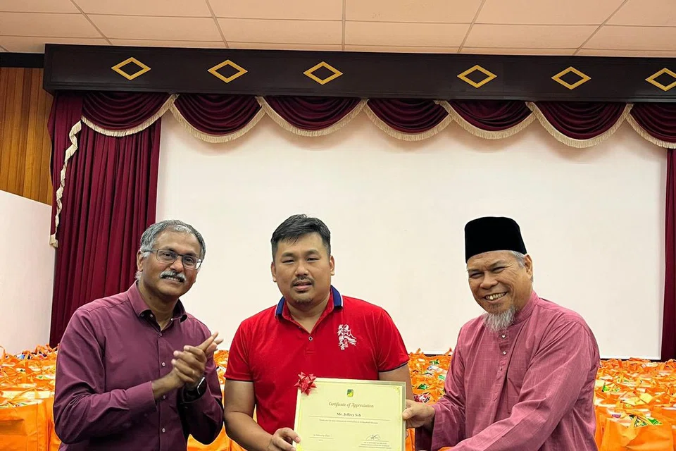 Presiden Kuil Tao, Encik Jeffrey Soh (tengah), menerima sijil penghargaan daripada Pengerusi  Eksekutif masjid Ar-Raudhah, Ustaz Mohamed Ali Atan (kanan), disaksikan Anggota Parlimen Bukit Batok, Encik Murali Pillai. 