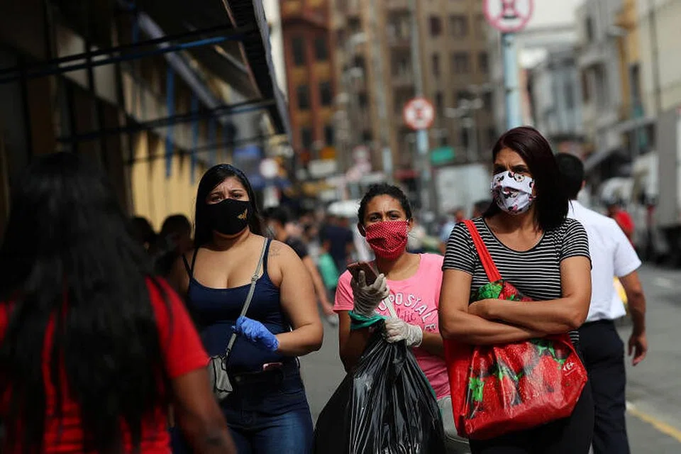 LINDUNG DIRI: Sekumpulan wanita dilihat memakai pelitup dan sarung tangan membawa beg semasa berbelanja setelah dewan bandar raya melonggarkan sekatan membendung penularan koronavirus di Sao Paulo, Brazil, semalam.