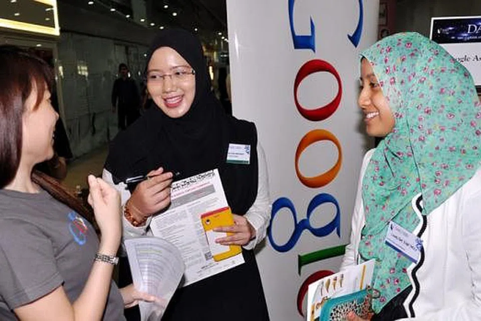 SEDIA CUBA BIDANG BARU: Cik Amalina (tengah) dan Cik Sharifah Fatimah (kanan) berbual dengan seorang kakitangan Google, Cik Cheryl Tang, di pameran kerjaya dan program bekerja sambil belajar SMU semalam. - Foto JOHARI RAHMAT