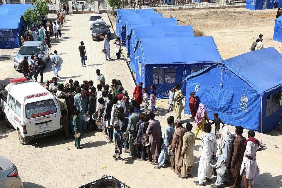 BERATUR PANJANG: Orang ramai yang terjejas akibat banjir kilat beratur untuk mendapatkan makanan di kem sementara yang disediakan oleh kerajaan Sindh di Hyderabad, wilayah Sindh, Pakistan.