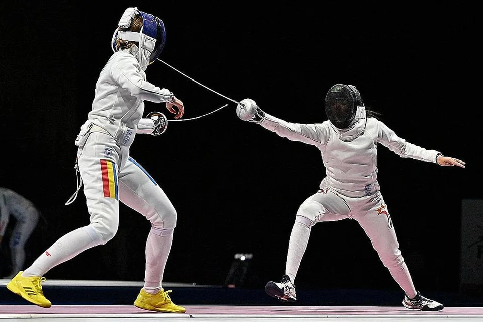 TAK GENTAR ASAK JAGUH DUNIA: Kiria Tikanah menyerang atlet lawan pedang No 1 dunia dari Romania, Ana Maria Popescu, dalam acara epee perseorangan wanita di Dewan Makuhari Messe Hall pagi semalam. Popescu menang 15-10 selepas Kiria merapatkan skor 10-11 dengan baki 35 saat dalam perlawanan. - Foto AFP