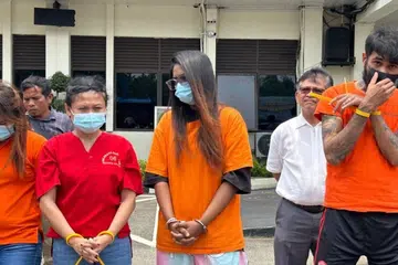 Warga Singapura yang dikenal pasti sebagai WSB (tengah) bersama suspek lain dalam kes dadah di ibu pejabat Polis Batam, Rempang dan Galang (Barelang), Batam, Kepulauan Riau, pada 17 September. Pihak berkuasa Indonesia menahan wanita itu selepas mengesyaki cara beliau berjalan yang kelihatan janggal sebelum menemukan 40 kartrij vape mengandungi etomidate yang didakwa disembunyikan di bahagian kelangkangnya.