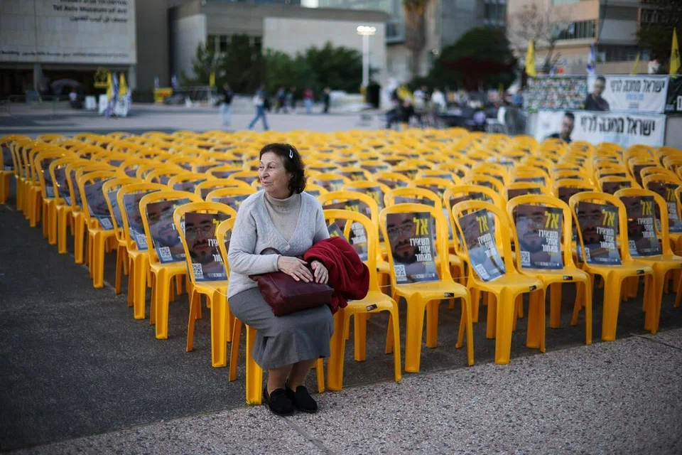 Seorang wanita Israel duduk di Dataran Tawanan di mana deretan kerusi dipamerkan bersama gambar pegawai polis Israel, Ran Gvili, yang diculik dalam serangan Hamas pada 7 Oktober 2023 dan yang mayatnya ditemui serta dikenal pasti di Gaza, menurut tentera Israel, di Tel Aviv, Israel, pada 26 Januari 2026.