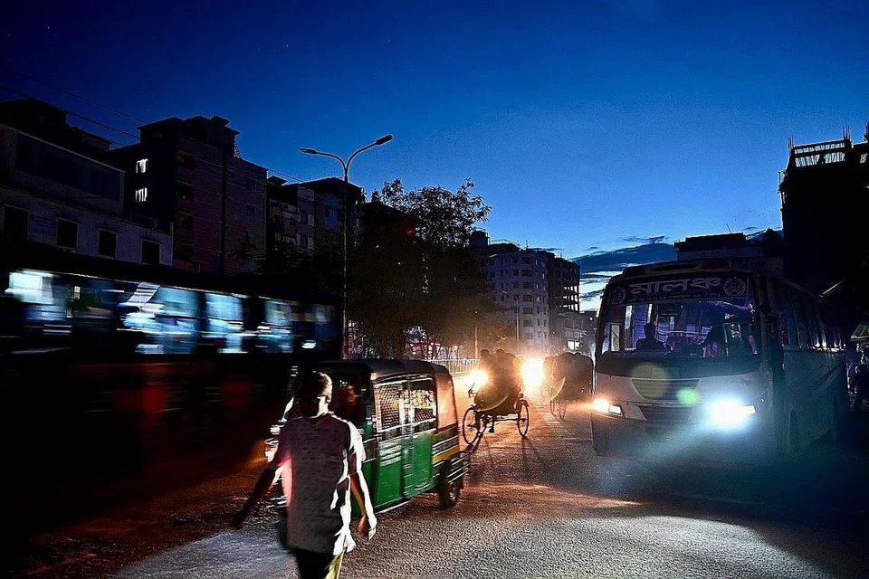 BERGELAP: Peniaga di pasar Dhaka menjual sayur-sayuran terpaksa menggunakan lilin akibat krisis bekalan elektrik di Bangladesh. (Atas) Orang ramai berjalan dalam keadaan gelap - Foto-foto AFP
