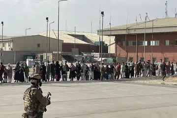 USAHA PEMINDAHAN: Warga Afghanistan kelihatan sedang beratur untuk menaiki pesawat tentera Itali di lapangan terbang Kabul. - Foto REUTERS