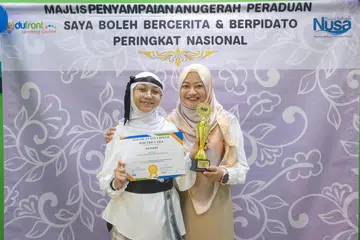 LEBIH YAKIN: Johan Kategori C ‘Saya Boleh Bercerita’, Nayla Zafirah Rozaini (kiri), yang bergambar bersama ibunya, Cik Nurwani Yacob, berkata peraduan itu memberinya keyakinan untuk bertutur dalam bahasa Melayu di hadapan orang ramai.