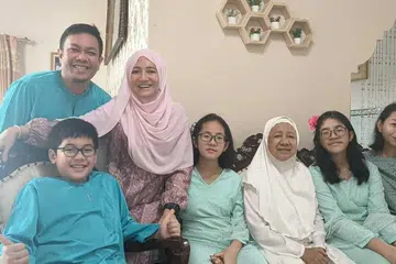 Cik Juniati Idris seronok bersama keluarganya menyambut Hari Raya Haji di perkampungan beliau.