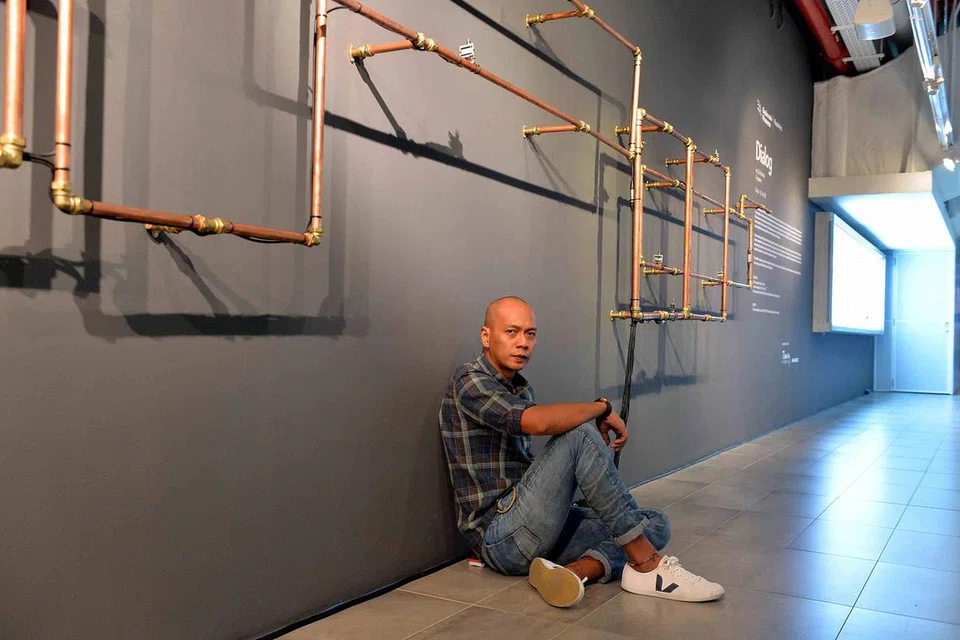 CABARAN JADI 'KONDUKTOR' PAIP: Artis seni pemasangan bunyian Zul Mahmod mewarnai terowong seni di Esplanade dengan struktur paip 70 meter yang mengalunkan lagu syahdu dan lagu rancak mengikut tema pesta di pusat seni itu. - Foto M.O. SALLEH