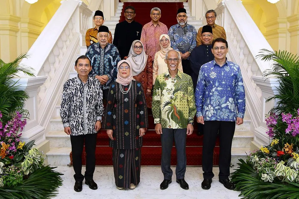 RAI JASA: Seramai sembilan individu daripada pelbagai latar belakang, termasuk Dr Ab Razak (baris paling belakang, tengah), disampaikan anugerah di upacara Anugerah Muis 2022 di Istana yang dihadiri Puan Halimah (baris depan, dua dari kiri). Turut hadir dalam majlis itu ialah (dari kiri) Encik Saat, Encik Masagos dan Encik Kadir. - Foto MUIS