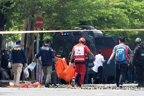 SERPIHAN MAYAT: Anggota forensik polis dilihat membawa beg mayat menyusuli satu percubaan untuk mengebom sebuah gereja di Makassar yang sedang menyambut minggu suci 'Palm Sunday'. Kededua suspek yang menaiki motosikal bagaimanapun tidak sempat masuk ke dalam gereja, sebaliknya ditahan di pekarangan gereja sebelum meledakkan letupan. - Foto EPA-EFE