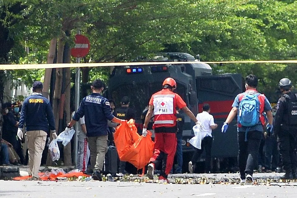 SERPIHAN MAYAT: Anggota forensik polis dilihat membawa beg mayat menyusuli satu percubaan untuk mengebom sebuah gereja di Makassar yang sedang menyambut minggu suci 'Palm Sunday'. Kededua suspek yang menaiki motosikal bagaimanapun tidak sempat masuk ke dalam gereja, sebaliknya ditahan di pekarangan gereja sebelum meledakkan letupan. - Foto EPA-EFE