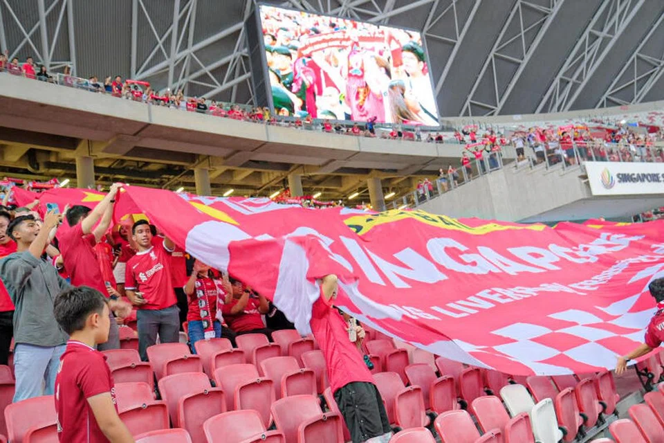 SUASANA RIUH: Penyokong Liverpool mengibarkan sepanduk kelab sebelum perlawanan bermula.