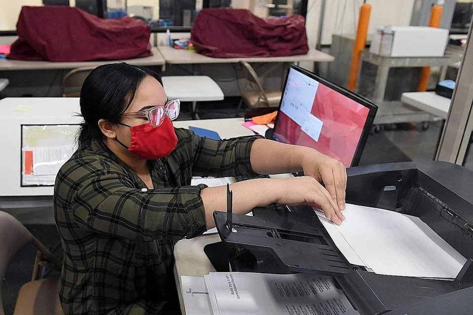 TERUS MENGIRA: Seorang pekerja pilihan raya Clark County mengimbas borang undi di Jabatan Pilihan Raya Clark County Las Vegas Utara, Nevada. Dua hari selepas pilihan raya, Presiden Donald Trump dan calon presiden Demokrat Joe Biden masih berada dalam persaingan sengit di negeri pertempuran. - Foto AFP