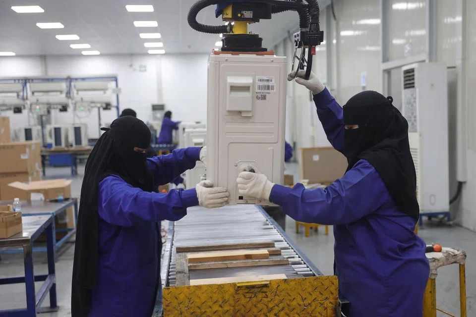 TURUT BEKERJA: Wanita Arab Saudi dilihat memasang alat hawa dingin di sebuah kilang di Dammam, di wilayah timur Arab Saudi pada 15 Ogos 2023.