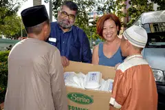 BAKTI TIDAK KIRA KAUM: Encik Nizar (dua dari kiri) bersama seorang sukarelawan FFFA, Cik Alyna Chong, mengagihkan makanan percuma di Darul Ihsan semalam. FFFA menganjurkan empat hingga lima pengagihan secara besar-besaran setiap tahun dan menyediakan 2,000 bungkusan setiap minggu. - Foto M.O. SALLEH