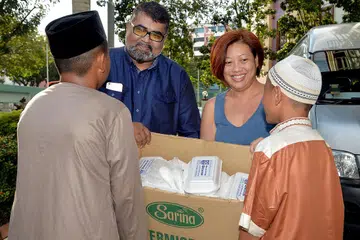 BAKTI TIDAK KIRA KAUM: Encik Nizar (dua dari kiri) bersama seorang sukarelawan FFFA, Cik Alyna Chong, mengagihkan makanan percuma di Darul Ihsan semalam. FFFA menganjurkan empat hingga lima pengagihan secara besar-besaran setiap tahun dan menyediakan 2,000 bungkusan setiap minggu. - Foto M.O. SALLEH