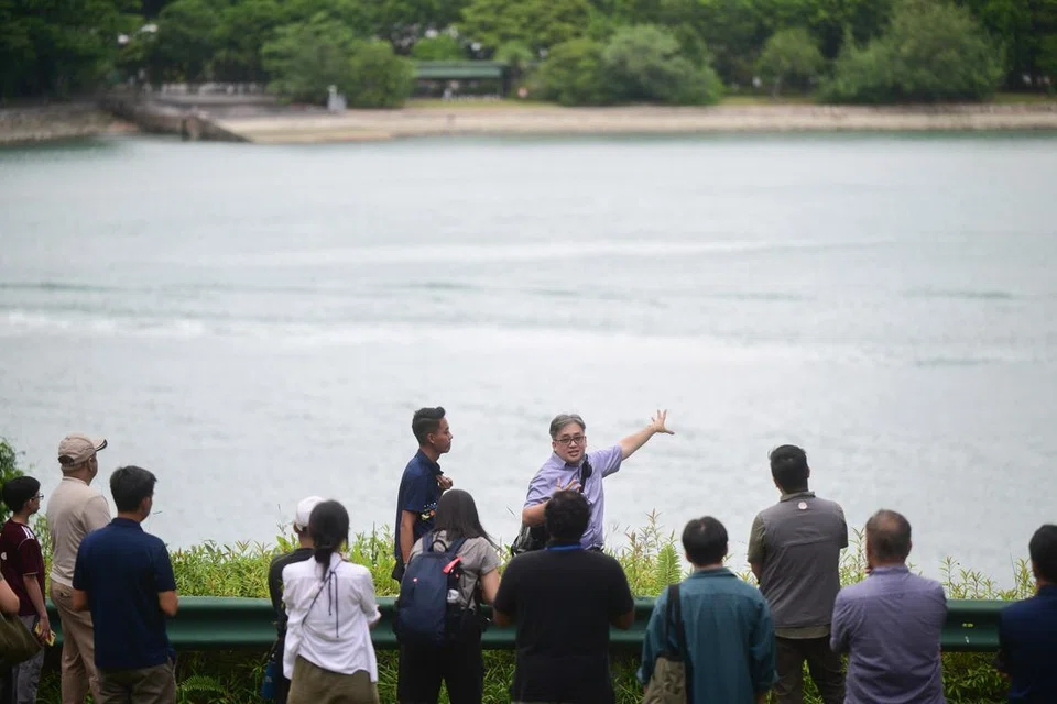 Sejarawan, Dr John Kwok (enam dari kanan), menunjuk ke arah Pelabuhan Keppel semasa sesi pratonton media pada 10 Februari. Fort Siloso dibina untuk mempertahankannya. 
