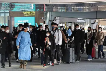 JALANI PEMERIKSAAN KESIHATAN WAJIB: Pengunjung dari China diiringi oleh pegawai kuarantin ke stesen ujian Covid-19 sebaik tiba di Lapangan Terbang Antarabangsa Incheon, Korea Selatan, kelmarin, apabila pemerintah Korea Selatan mula mewajibkan ujian PCR ke atas semua pelancong dari China memandangkan virus itu kini merebak dengan meluas di negara jiran. - Foto EPA-EFE