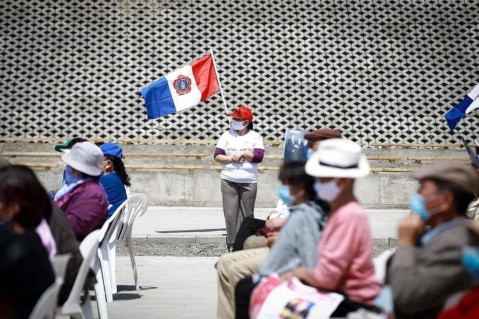 MONGOLIA BERTINDAK PANTAS: Seorang wanita kelihatan memegang bendera Parti Rakyat Mongolia di Ulaanbaatar pada 5 Jun. Walaupun merupakan antara negara miskin, tindakan pantas Mongolia mengelakkan jumlah kes yang tinggi di negara itu. - Foto AFP