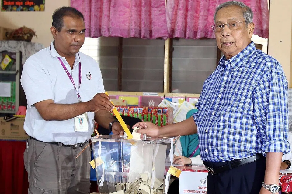KEJAYAAN KETUA MENTERI: Ketua Menteri Sarawak, Tan Sri Adenan Satem (kanan), semasa mengundi di pusat pengundian di Kuching dalam Pilihan Raya Negeri Sarawak ke-11, Sabtu lalu. - Foto AFP