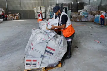 HULUR BANTUAN: Seorang pegawai Sabit Merah kelihatan sedang membungkus bahan-bahan bantuan kemanusiaan bagi rakyat Palestin yang berada di Gaza sedang konflik ketegangan antara Israel dengan Gaza berterusan.
