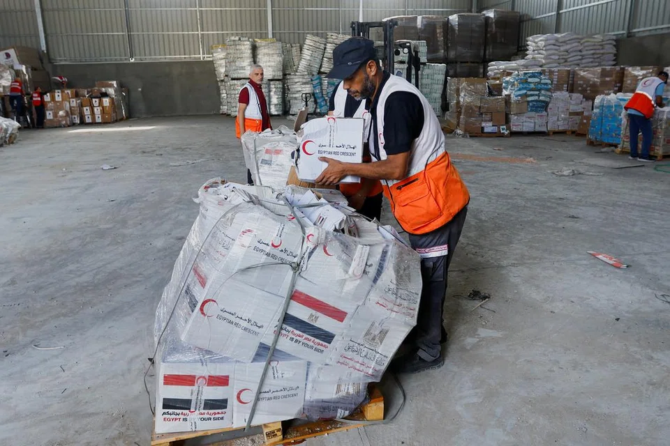 HULUR BANTUAN: Seorang pegawai Sabit Merah kelihatan sedang membungkus bahan-bahan bantuan kemanusiaan bagi rakyat Palestin yang berada di Gaza sedang konflik ketegangan antara Israel dengan Gaza berterusan.