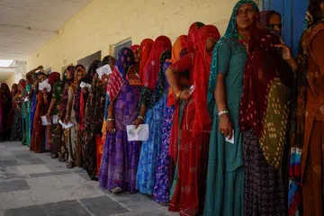 Pengundi wanita berdiri dalam barisan untuk membuang undi di pusat mengundi semasa fasa kedua pilihan raya umum, di Barmer, Rajasthan, India.