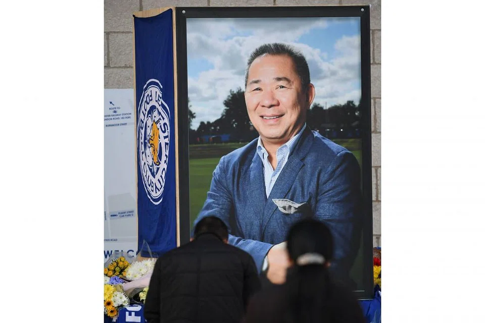 PENGHORMATAN TERAKHIR: Pemilik kelab bola sepak Leicester City, Vichai Srivaddhanaprabha, begitu disayangi peminat. Kelihatan dalam gambar atas, dua daripada ratusan ribu penyanjungnya memberi penghormatan terakhir kepadanya. - Foto AFP