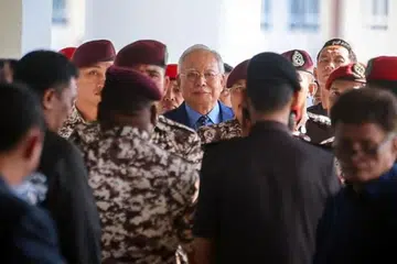 Mantan Perdana Menteri Malaysia, Encik Najib Tun Razak (tengah), kini di peringkat membela diri di Mahkamah Tinggi Kuala Lumpur atas empat tuduhan menggunakan kedudukan bagi memperoleh suapan berjumlah RM2.3 bilion ($0.68 bilion) dana 1Malaysia Development Berhad (1MDB) dan 21 tuduhan pengubahan wang haram.