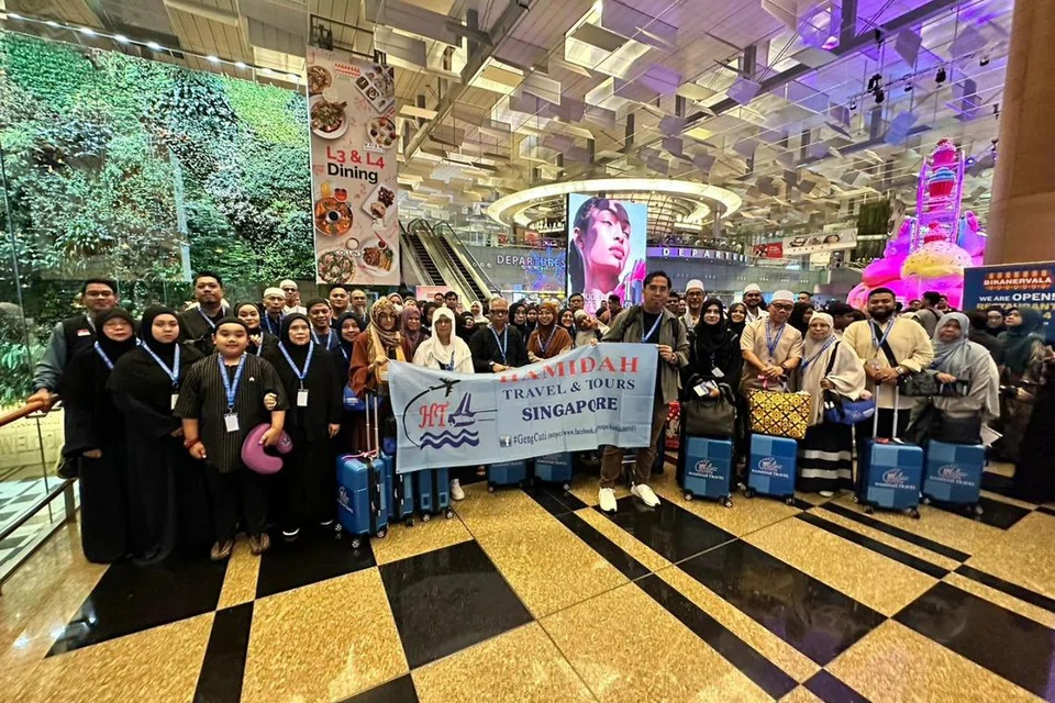 BERANGKAT: Kumpulan jemaah umrah ke-26 bagi 2023 daripada Hamidah Travel & Tours bergambar di Lapangan Terbang Changi Terminal 3 sebelum berlepas ke Makkah pada 28 November.