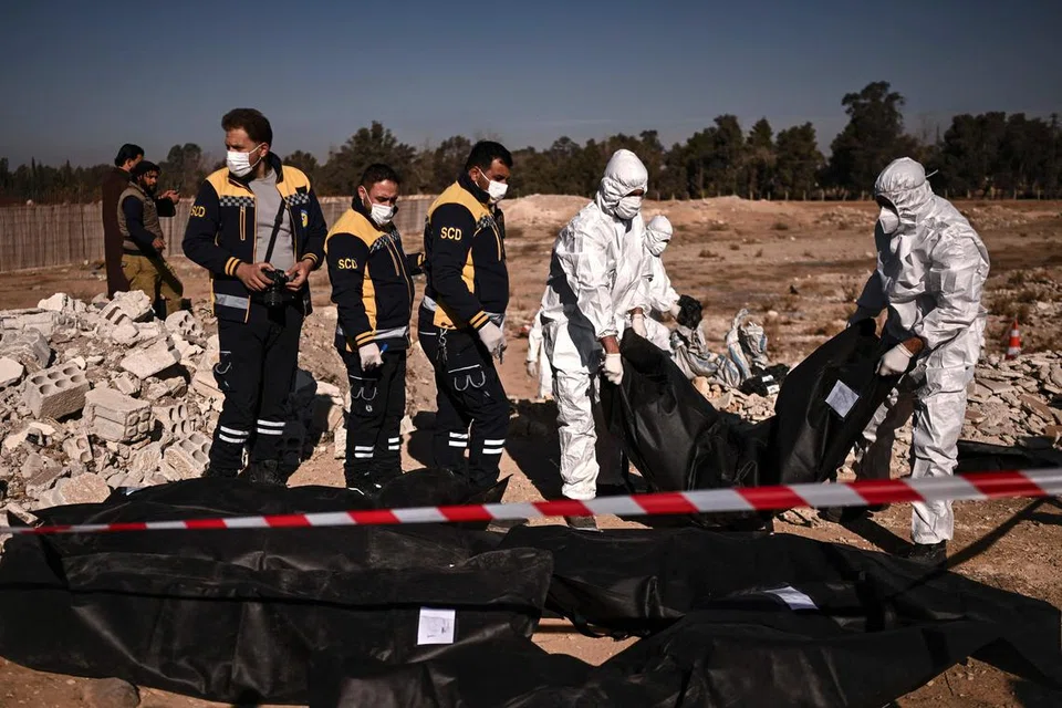 Anggota White Helmets Syria mengangkut beg mayat mengandungi sisa manusia yang ditemui di kubur besar di Damsyik pada 16 Disember.